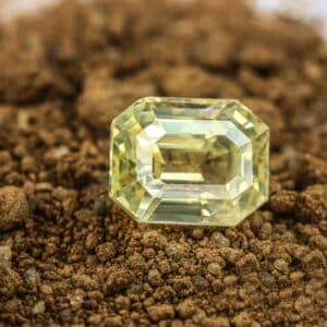 Yellow sapphire gem on soil