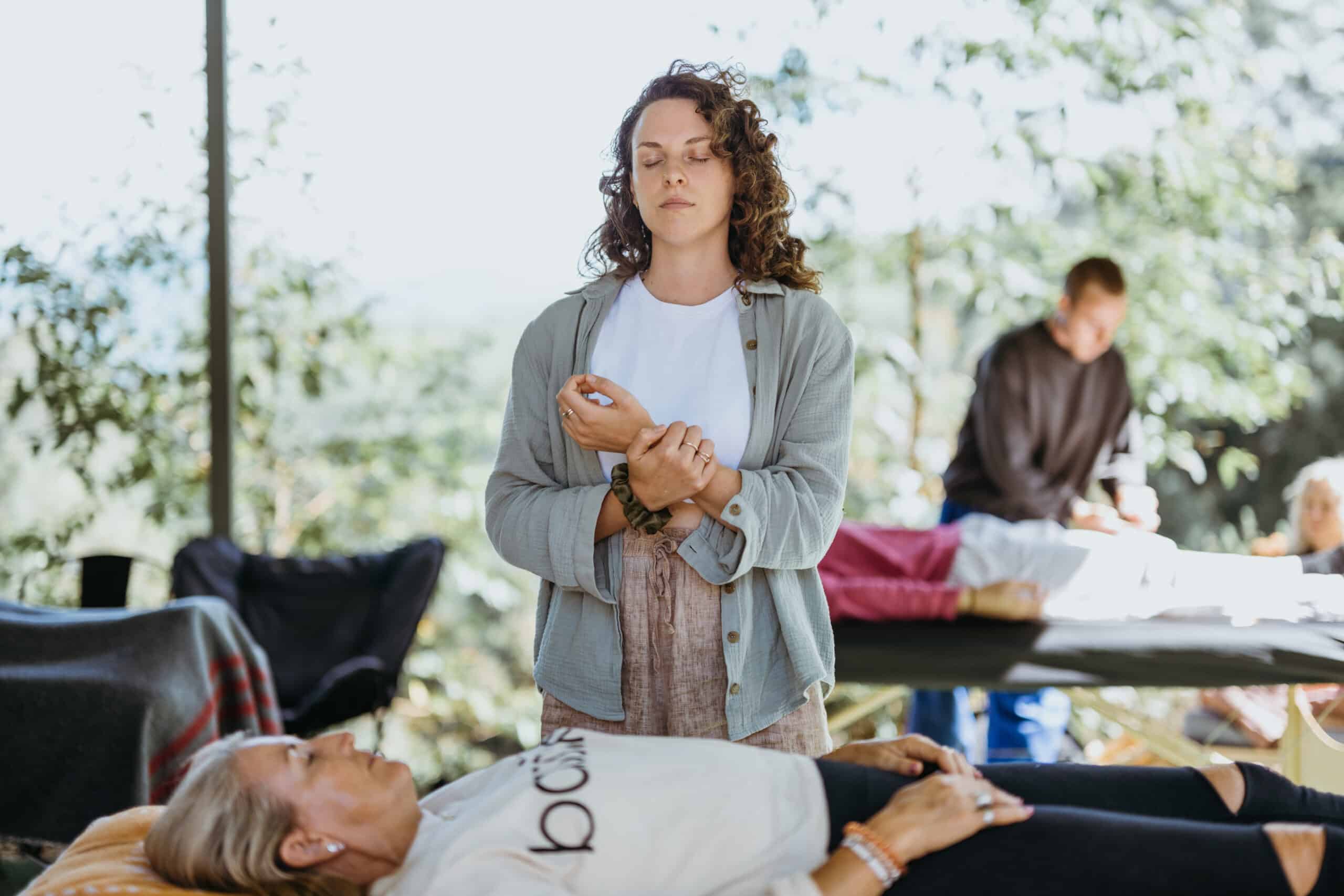 A student feeling her pulse before commencing the marma practice